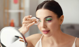 Women looking at a make mirror and removing her make up around her eyes with a make up removal pad